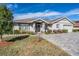 Charming single-story home featuring a well-manicured lawn and a patterned brick driveway at 29307 Schinnecock Hills Ln, San Antonio, FL 33576