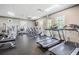 Bright fitness center with treadmills, stationary bikes, and natural light from large windows at 29307 Schinnecock Hills Ln, San Antonio, FL 33576