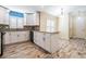 Well-lit kitchen featuring white cabinets, modern appliances, granite counters, and wood-look floors at 29307 Schinnecock Hills Ln, San Antonio, FL 33576