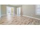 Bright living room with wood-look floors, neutral paint, and sliding glass doors to outside at 29307 Schinnecock Hills Ln, San Antonio, FL 33576