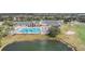 Aerial view showcases a large community pool, set beside a pond and golf course at 29307 Schinnecock Hills Ln, San Antonio, FL 33576