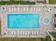 Aerial view of a rectangular community pool featuring ample seating and a relaxing jacuzzi area at 2983 Bonaventure Cir # 204, Palm Harbor, FL 34684