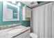 Cozy bathroom with teal walls, granite countertop, and shower at 2983 Bonaventure Cir # 204, Palm Harbor, FL 34684