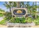 An elegant community sign surrounded by lush greenery and colorful flowers welcomes residents to Bonaventure at 2983 Bonaventure Cir # 204, Palm Harbor, FL 34684