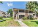 Attractive condo building with a well-kept lawn, vibrant landscaping, and visible unit numbers at 2983 Bonaventure Cir # 204, Palm Harbor, FL 34684