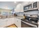 This kitchen features white cabinets, stainless steel appliances and speckled granite countertops at 2983 Bonaventure Cir # 204, Palm Harbor, FL 34684