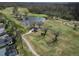 Picturesque aerial of the golf course featuring a pond, cart path, and golfers on the green at 3822 Salida Delsol Dr, Sun City Center, FL 33573