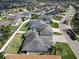 Aerial view of homes in neighborhood streetscape with well-maintained lawns and mature trees at 3822 Salida Delsol Dr, Sun City Center, FL 33573