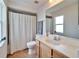 Bright bathroom featuring a tile floor, shower with curtain, vanity sink, and a large mirror at 3822 Salida Delsol Dr, Sun City Center, FL 33573