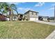 Charming front exterior with three-car garage and a well-manicured lawn at 3822 Salida Delsol Dr, Sun City Center, FL 33573