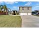 Charming front exterior with three-car garage and a well-manicured lawn at 3822 Salida Delsol Dr, Sun City Center, FL 33573