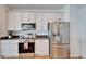 Bright kitchen featuring stainless steel appliances, granite counters and sleek white cabinetry at 3822 Salida Delsol Dr, Sun City Center, FL 33573