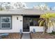 Charming single-story home features a screened porch and decorative lion statues at the entrance at 3942 La Costa Ln, Largo, FL 33771