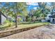 Sprawling backyard with lush greenery, a covered area with dining, and well-maintained landscaping at 472 Pine St, Tarpon Springs, FL 34689