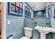 Charming blue-tiled bathroom features artistic decor, a pedestal sink, and a toilet at 472 Pine St, Tarpon Springs, FL 34689