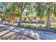 Well-maintained home featuring a landscaped yard, a secure fence, and mature shade trees at 472 Pine St, Tarpon Springs, FL 34689