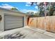 Garage exterior with a wooden fence, and a garden wall art at 472 Pine St, Tarpon Springs, FL 34689