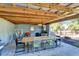 Covered outdoor dining area with a chandelier, a hammock and dining table ideal for outdoor gatherings at 472 Pine St, Tarpon Springs, FL 34689