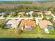 Aerial view of homes with screened-in pools, lush landscaping, and lake in the background at 4873 Quill Ct, Palm Harbor, FL 34685