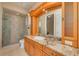 Well-lit bathroom with granite countertops, custom cabinetry, and a glass-enclosed shower at 4873 Quill Ct, Palm Harbor, FL 34685