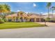 Beautiful two-story yellow home with a well-manicured lawn, three-car garage, and a striking red tile roof at 4873 Quill Ct, Palm Harbor, FL 34685