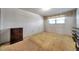 Bedroom featuring neutral colored walls, window with curtain, carpeted floor, and wood cabinet at 5925 Shore S Blvd # 406, Gulfport, FL 33707