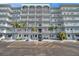 Condominium building entrance features palm trees, tropical plants, and visitor parking at 5925 Shore S Blvd # 406, Gulfport, FL 33707