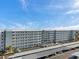 Multi-story condominium with a parking lot and beautiful blue sky at 5925 Shore S Blvd # 406, Gulfport, FL 33707