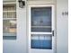 The front door with storm door of unit 406, alongside a window and exterior light at 5925 Shore S Blvd # 406, Gulfport, FL 33707