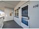 Exterior front door of unit 406 with a porch, window, and light fixture at 5925 Shore S Blvd # 406, Gulfport, FL 33707