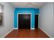 Bright bedroom with hardwood floors, blue accent wall, and black closet doors at 6222 Kingbird Manor Dr, Lithia, FL 33547