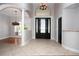 The foyer features tile flooring, a chandelier, arched entryway, and black paneled front door at 6222 Kingbird Manor Dr, Lithia, FL 33547