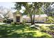 Charming single-story home with manicured lawn and landscape, featuring a columned portico entryway and arched windows at 6222 Kingbird Manor Dr, Lithia, FL 33547