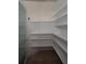 Walk-in pantry with white shelving and tile flooring for optimal storage space at 6222 Kingbird Manor Dr, Lithia, FL 33547