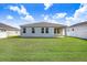 Backyard view of the home's rear exterior with a covered patio and green lawn at 6307 113Th E Ter, Parrish, FL 34219