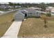 Aerial view of a single-Gathering home showcasing its well-manicured lawn, long driveway, and two-car garage at 7056 Landover Blvd, Spring Hill, FL 34608