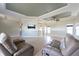 Open concept living room featuring tray ceiling, modern furniture and neutral paint for a comfortable living space at 7056 Landover Blvd, Spring Hill, FL 34608