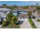 Birds-eye view of a charming blue home featuring a large driveway, a well-manicured lawn, and lush landscaping at 7284 Pebble Beach Ln, Seminole, FL 33777