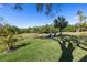 Expansive backyard featuring lush greenery, mature palms, and outdoor seating area for relaxing at 7284 Pebble Beach Ln, Seminole, FL 33777