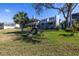 Spacious backyard with beautiful fire pit area, lush lawn, and mature trees at 7284 Pebble Beach Ln, Seminole, FL 33777