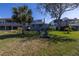 Large backyard featuring mature landscaping, beautiful lawn, and lovely seating area at 7284 Pebble Beach Ln, Seminole, FL 33777