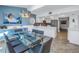 Dining area features a glass table, modern light fixture, and views of the updated kitchen at 7284 Pebble Beach Ln, Seminole, FL 33777