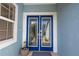 Close-up of the home's elegant double front doors, with decorative glass and a fresh blue finish at 7284 Pebble Beach Ln, Seminole, FL 33777