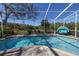 Sparkling pool surrounded by a screen enclosure and lush greenery at 7284 Pebble Beach Ln, Seminole, FL 33777