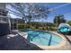 Clear blue pool surrounded by brick pavers and enclosed with a pool screen at 7284 Pebble Beach Ln, Seminole, FL 33777