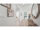 Bright hallway with neutral paint, tile floor, and decorative wall accents leading to other rooms at 7804 Wheat Stone Dr, Zephyrhills, FL 33540