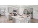 Well-lit kitchen with a center island, barstool seating, and stainless steel appliances at 7804 Wheat Stone Dr, Zephyrhills, FL 33540