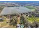 Expansive aerial view of the property with farmland, wooded areas, and a residence at 8408 Bob Wiggs Ave, Lithia, FL 33547