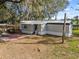 Exterior view of single-story home with a metal roof and gray siding at 8408 Bob Wiggs Ave, Lithia, FL 33547