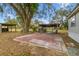 Home's outdoor patio area with large tree and shed with metal roofing at 8408 Bob Wiggs Ave, Lithia, FL 33547